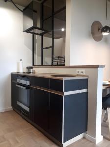 a kitchen with a black and white counter and a desk at Lieblingsplatz am Kurpark in Brilon