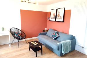 a living room with a blue couch and a table at Le Rêve Suspendu in Le Havre