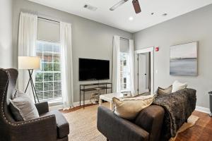 a living room with two chairs and a television at NEW LISTING The Townie Retreat - Walk to Stadium in Athens
