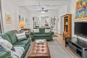 a living room with two green couches and a tv at Lenoir Cottage w covered patio and fire pit in Athens