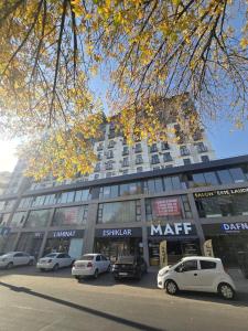 a large building with cars parked in front of it at Conveniently located near the Tashkent City area, close to the city center in Tashkent