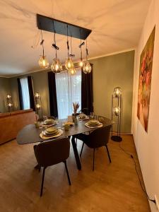 a dining room with a table and chairs and lights at Zentral und Stilvoll Nahe Kurpark und Bali Therme in Bad Oeynhausen