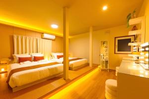 a hotel room with two beds and a television at Tokinoma Furano in Furano