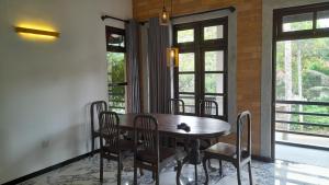 a dining room with a wooden table and chairs at The Belle Denipitiya in Welihinda