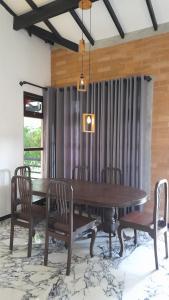 a dining room with a wooden table and chairs at The Belle Denipitiya in Welihinda