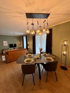 a living room with a dining room table and chairs at Klinik & Kurpark Parkplatz Barrierefreies Apartment Boxspringbett in Bad Oeynhausen