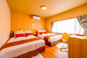 a hotel room with two beds and a window at Tokinoma Furano in Furano