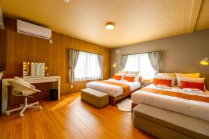 a hotel room with two beds and a desk at Tokinoma Furano in Furano