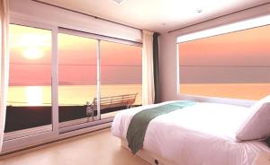 Un dormitorio con una cama y una ventana grande. en Amy Bada, en Incheon