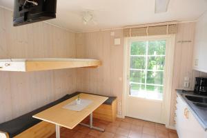 una pequeña cocina con mesa y ventana en Apelvikens Camping & Cottages, en Varberg