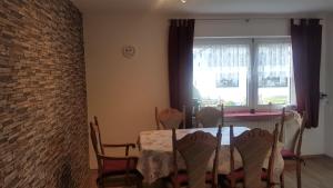 a dining room with a table and a brick wall at Ferienwohnung Ziegler in Steinau an der Straße
