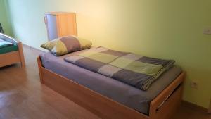 a small bed in a room with a wooden floor at Ferienwohnung Ziegler in Steinau an der Straße