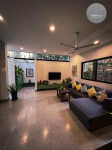Una sala de estar con un sofá y un ventilador de techo. en Tropical Garden House, en Siem Reap