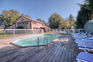 a swimming pool with lounge chairs on a wooden deck at Chambre D’hôtes La Bonne Mine in Le Fraysse