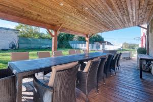 a wooden deck with a long table and chairs at Chambre D’hôtes La Bonne Mine in Le Fraysse