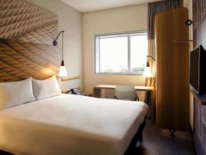 オザスコにあるibis Osascoのベッドと机と窓があるホテルの部屋 +41枚の写真