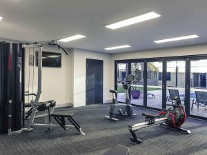 a gym with several treadmills and elliptical machines at Mercure Tamworth in Tamworth