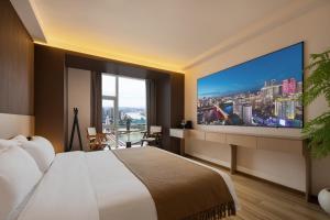 a hotel room with a large bed and a large screen tv at Liberation Monument Riverside HoteL in Nan'an
