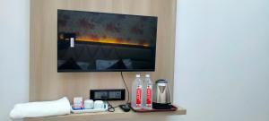 a room with a tv and some drinks on a shelf at Kashi Satya Luxury Stay in Varanasi