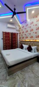 a bedroom with a large bed with a ceiling fan at Kashi Satya Luxury Stay in Varanasi