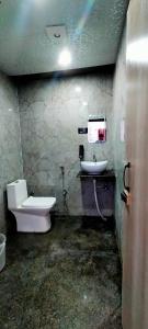 a dirty bathroom with a toilet and a sink at Kashi Satya Luxury Stay in Varanasi