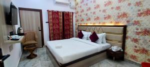 a hotel room with a bed and a television at Kashi Satya Luxury Stay in Varanasi +3 photos