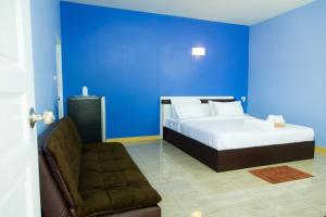 a blue bedroom with a bed and a couch at P House in Kanchanaburi City