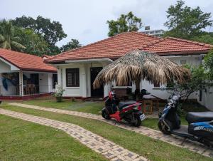two motorcycles parked in front of a house at Canopy villas in Mirissa +6 photos