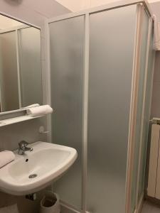 a bathroom with a glass shower and a sink at Hotel Villa Ferrara in Chianciano Terme +2 photos