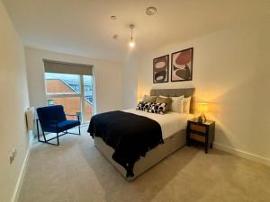 ブラックネルにあるModern 1 bed apartment, The Grand Exchangeのベッドルーム(大型ベッド1台、青い椅子付)