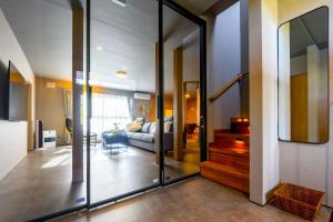 a living room with a couch and a glass door at Tokinoma Furano in Furano