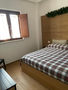 a bedroom with a bed with a plaid blanket at La Pulchella in LʼAquila