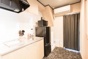 a kitchen with a black refrigerator and a sink at b&黒門1号店 in Osaka +22 photos