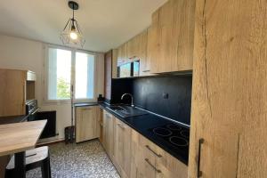 a kitchen with wooden cabinets and a sink and a window at Le ciel havrais in Le Havre