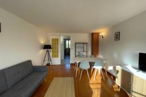 a living room with a couch and a table and chairs at Le ciel havrais in Le Havre