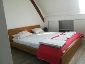 a bedroom with a bed with white sheets and red blanket at Mbine Senghore in Hérouville-Saint-Clair