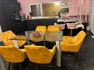 a dining room with a glass table and yellow chairs at Stadthaus Amanda in Weimar +13 photos