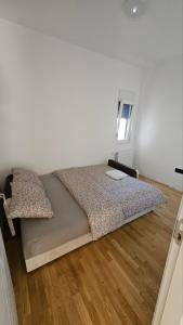 a bedroom with a bed and a wooden floor at Spring 2 in Petrovaradin