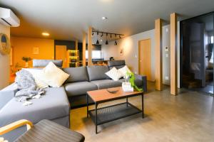 a living room with a couch and a table at Tokinoma Furano in Furano