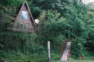 a small house with a staircase leading up to it at White Magpie Mountain Residence in Qiduhe