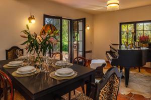 a dining room with a table and a piano at Villa Art Vita - Private Pool, Sauna & River Access in Donji Zvečaj