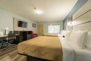 a hotel room with a bed and a desk with a computer at Quality Inn & Suites Manitou Springs at Pikes Peak in Manitou Springs