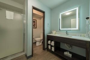 a bathroom with a sink and a toilet and a mirror at Quality Inn & Suites Manitou Springs at Pikes Peak in Manitou Springs +63 photos