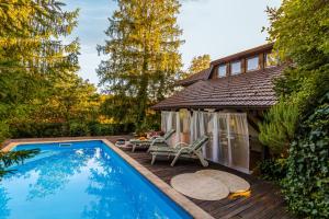 a swimming pool on a deck next to a house at Villa Art Vita - Private Pool, Sauna & River Access in Donji Zvečaj