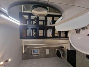 a bathroom with a sink and a mirror at Retroversum Themen-Ferienwohnung in Bad Oeynhausen