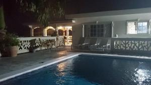 a swimming pool in front of a house at night at Bayview Luxury Retreat in Montego Bay