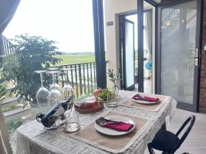 a table with plates and glasses on a balcony at Betel Hoi An Homestay in Cam Thanh