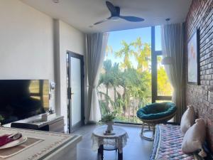 a living room with a couch and a ceiling fan at Betel Hoi An Homestay in Cam Thanh