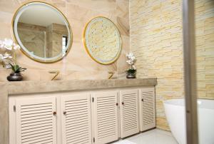 a bathroom with a sink and two mirrors at Beyond Borders Guest House in Polokwane +68 photos