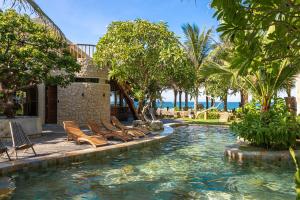 a pool with chairs and the ocean in the background at Sun Village Beach Resort in Tuy Hoa